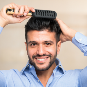 man brushing his hair and smiling